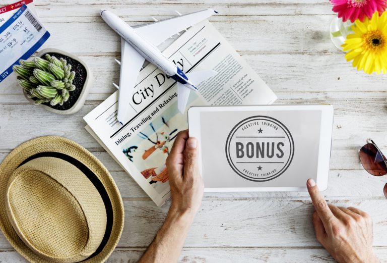 Person holding a tablet with a screen that says "Bonus"