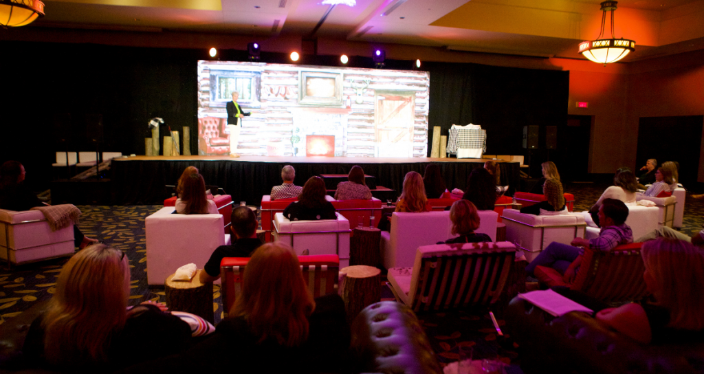 Face to Face Meeting where business woman is talking on stage.